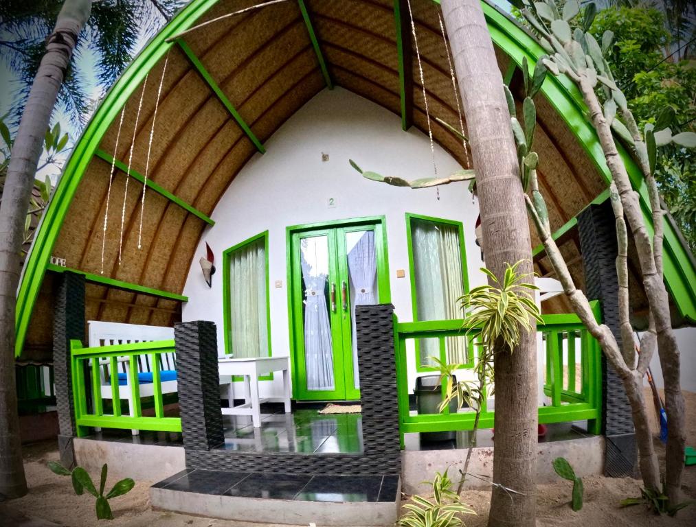a house on the beach with green and white at Kaktus bungalow 1 in Gili Air