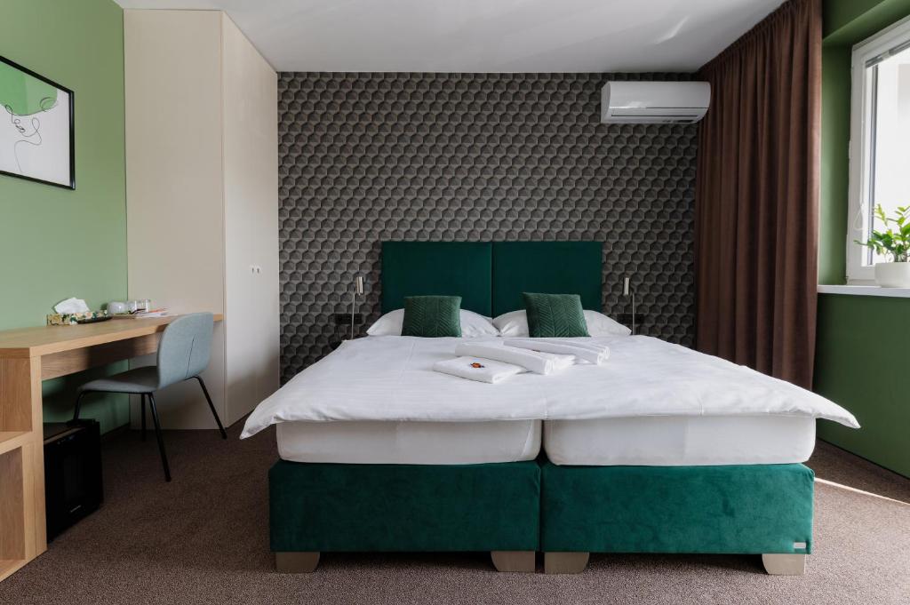 尼特拉的住宿－Penzion Tofi，卧室配有绿色和白色的床和书桌。