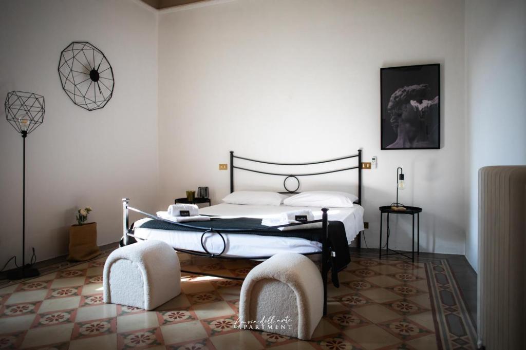 a bedroom with a bed and two chairs in it at La via dell'arte Apartment in Pescara