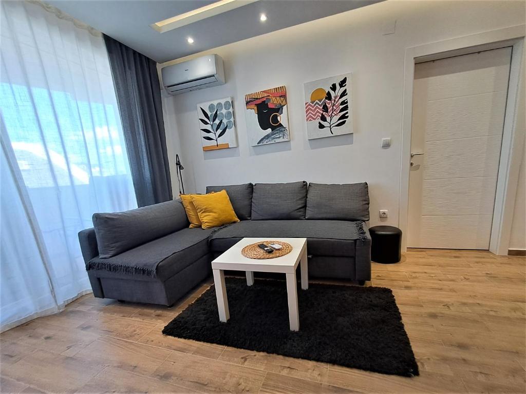 sala de estar con sofá y mesa en Apartman 64 Lux en Veliko Gradište