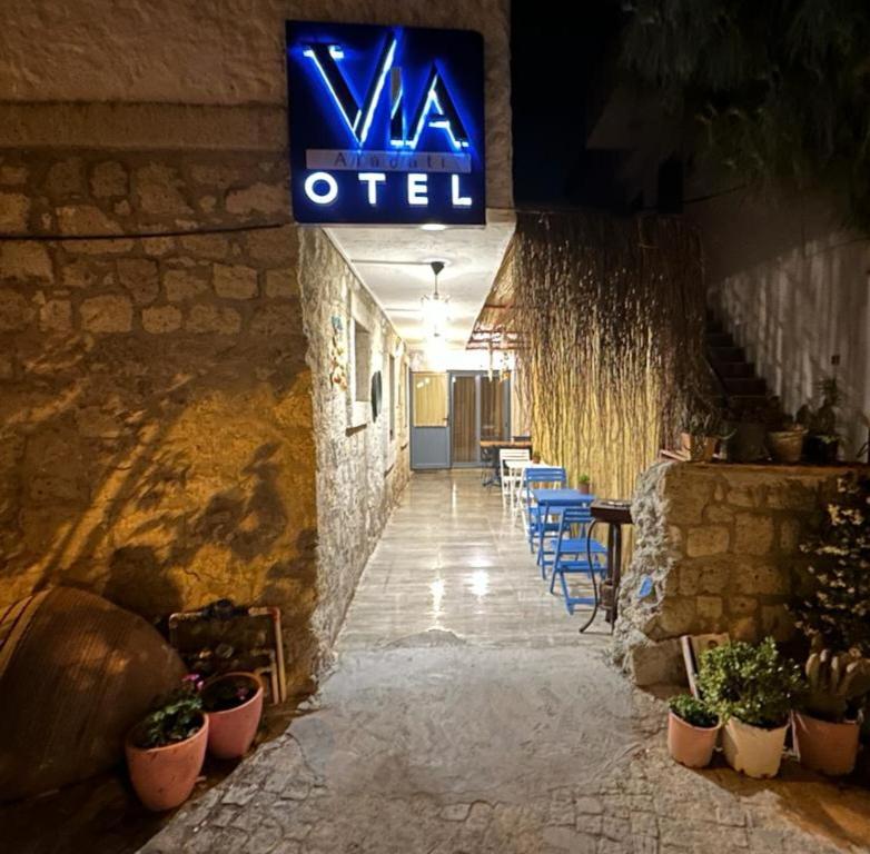 een bord aan de zijkant van een gebouw met planten bij Via Alaçatı Otel in Çeşme