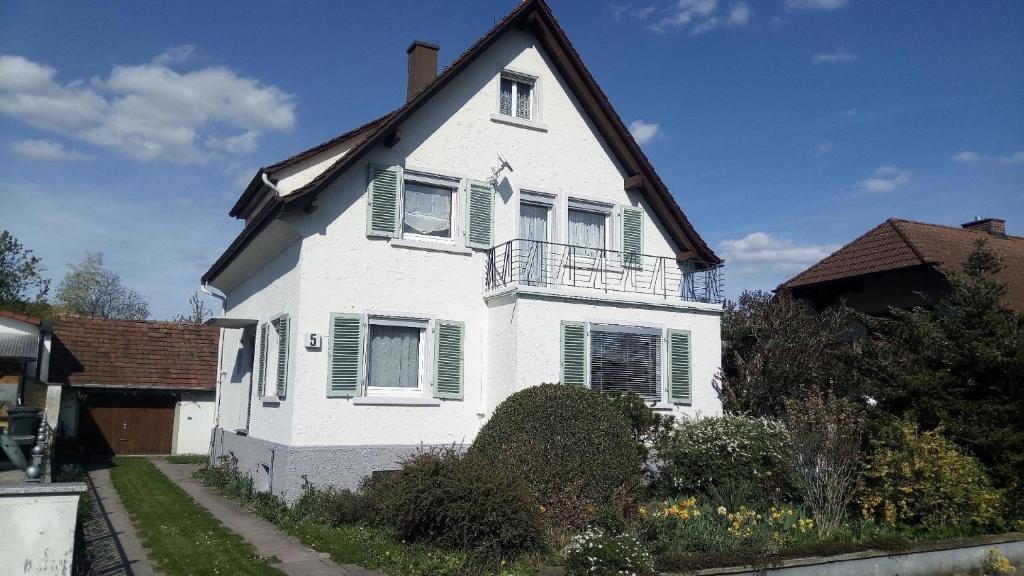 Biały dom z zielonymi okiennicami w obiekcie Ferienhaus in ruhiger Lage mit großem Garten w mieście Orsingen-Nenzingen