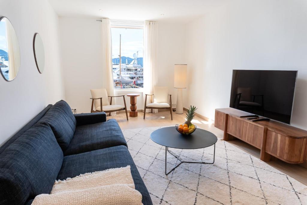 un salon avec un canapé bleu et une télévision dans l'établissement Port de Saint-Tropez, à Saint-Tropez