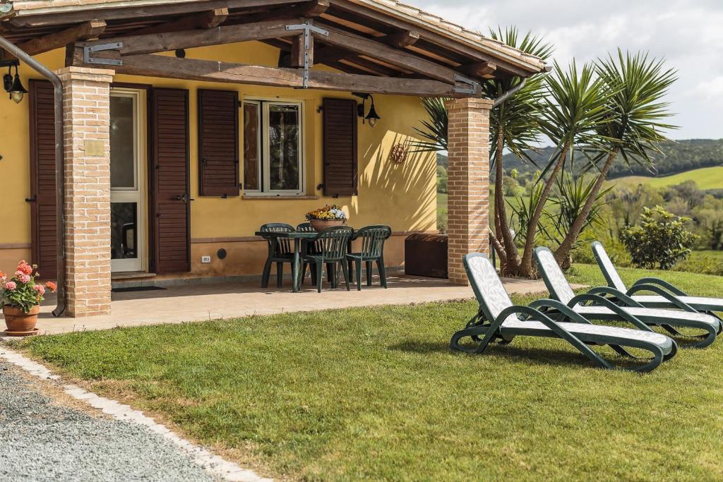 a group of chairs sitting in the grass in front of a house at Agriturismo Cupido in Montiano