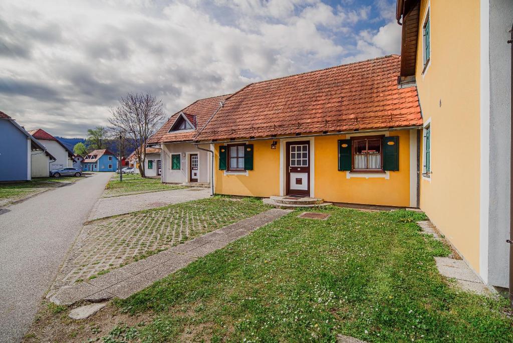 a yellow house with a red roof on a street at Spa House Alenka Terme Čatež in Čatež ob Savi