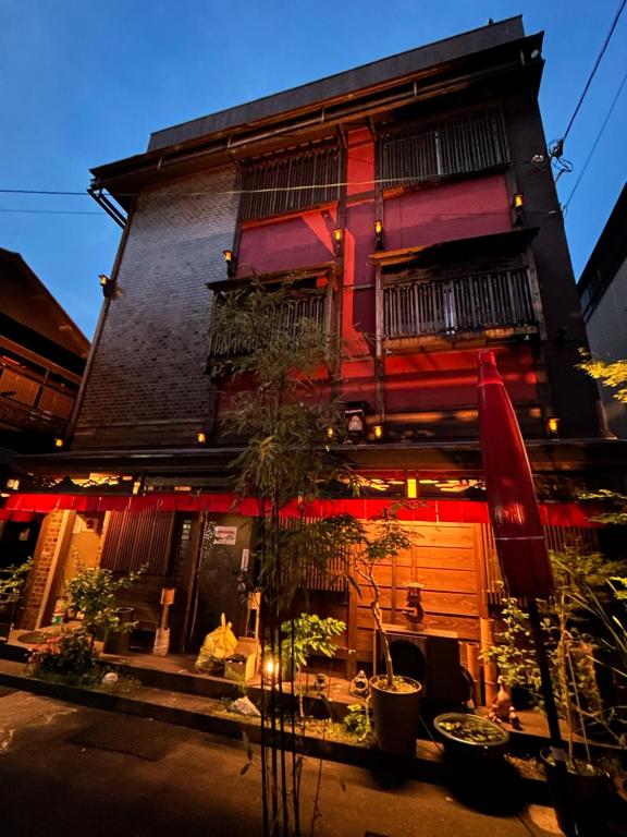 ein Gebäude mit Pflanzen davor in der Unterkunft Benidaruma - Sakuramochi in Kyoto