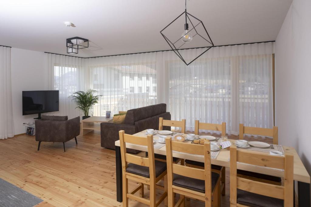 a dining room and living room with a table and chairs at Chasa Helvetia Duai in Müstair
