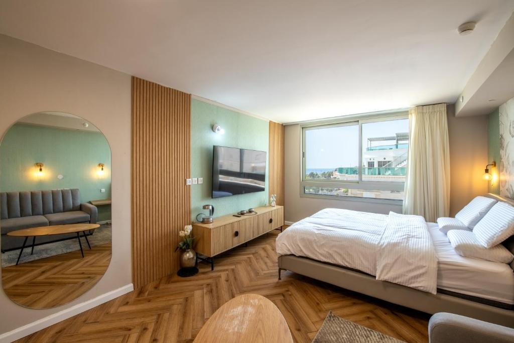1 dormitorio con cama y ventana grande en סיסייד אילת חדר עם נוף לים - Seaside Eilat Room With Sea View en Eilat