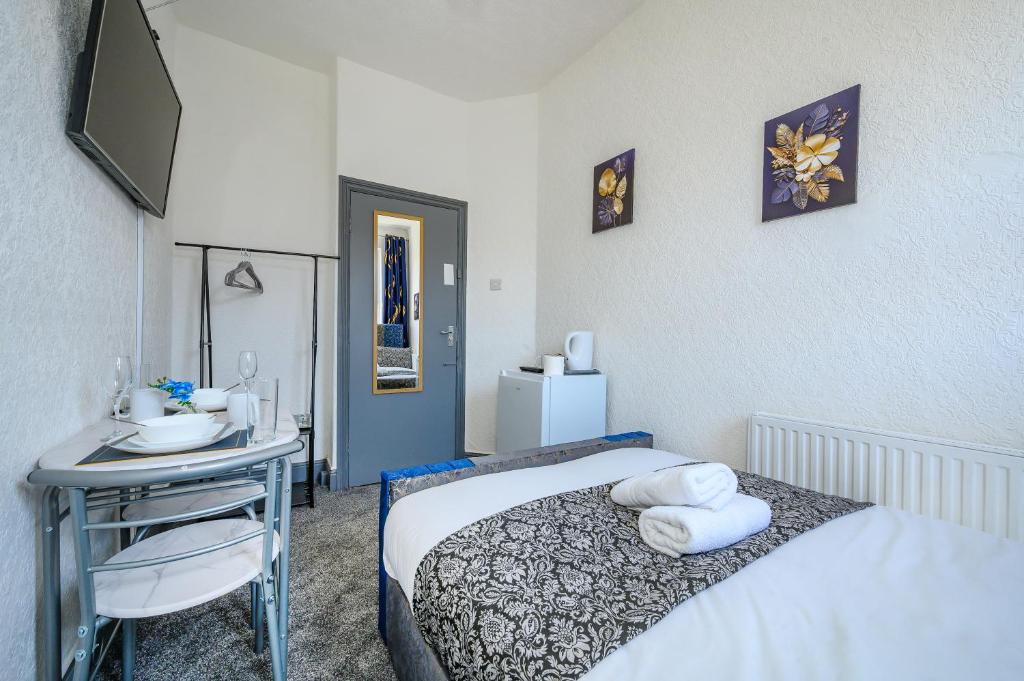 a small room with a bed and a table and a television at -RC7H- For your relaxed & Cosy Free Parking in Leeds