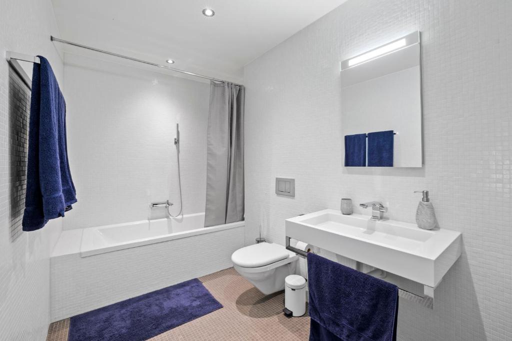 a white bathroom with a sink and a toilet at Exclusive spacious Apt. with garden in Zurich in Zürich