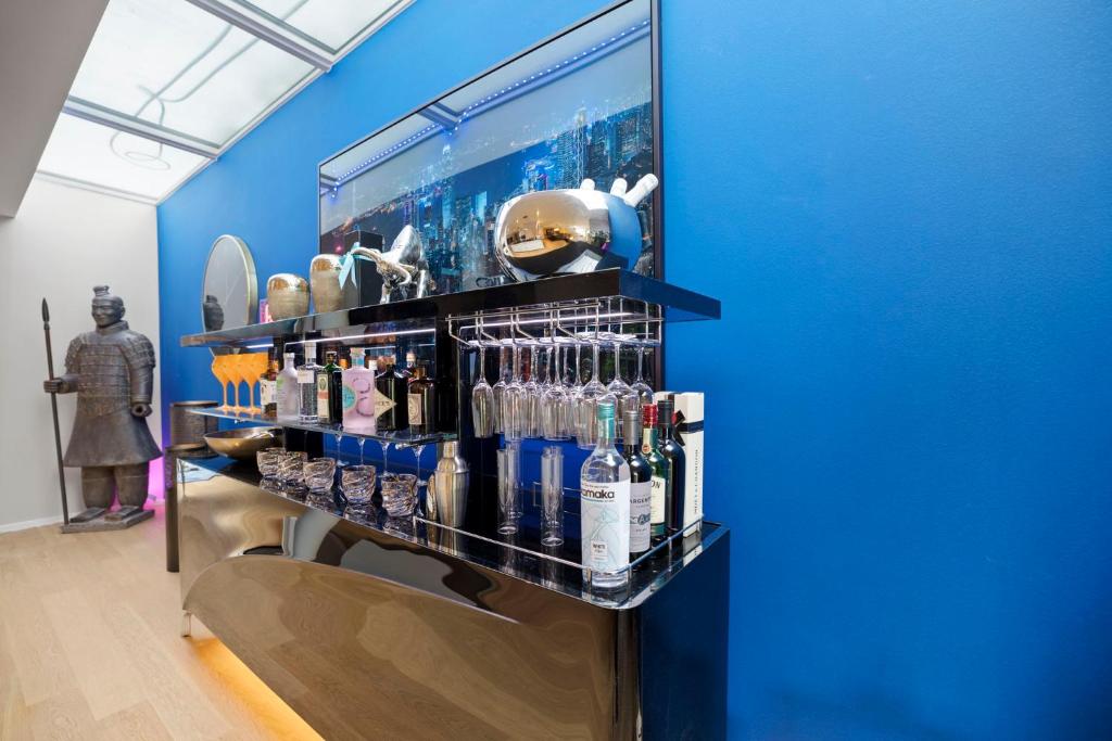 a shelf with bottles of alcohol on a blue wall at Exclusive spacious Apt. with garden in Zurich in Zürich