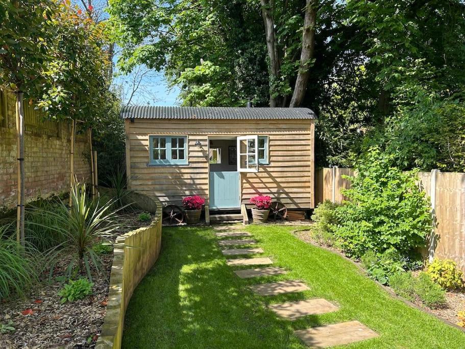 a tiny house in a yard with a fence at Shepherd's Hut at The Granary in Steyning