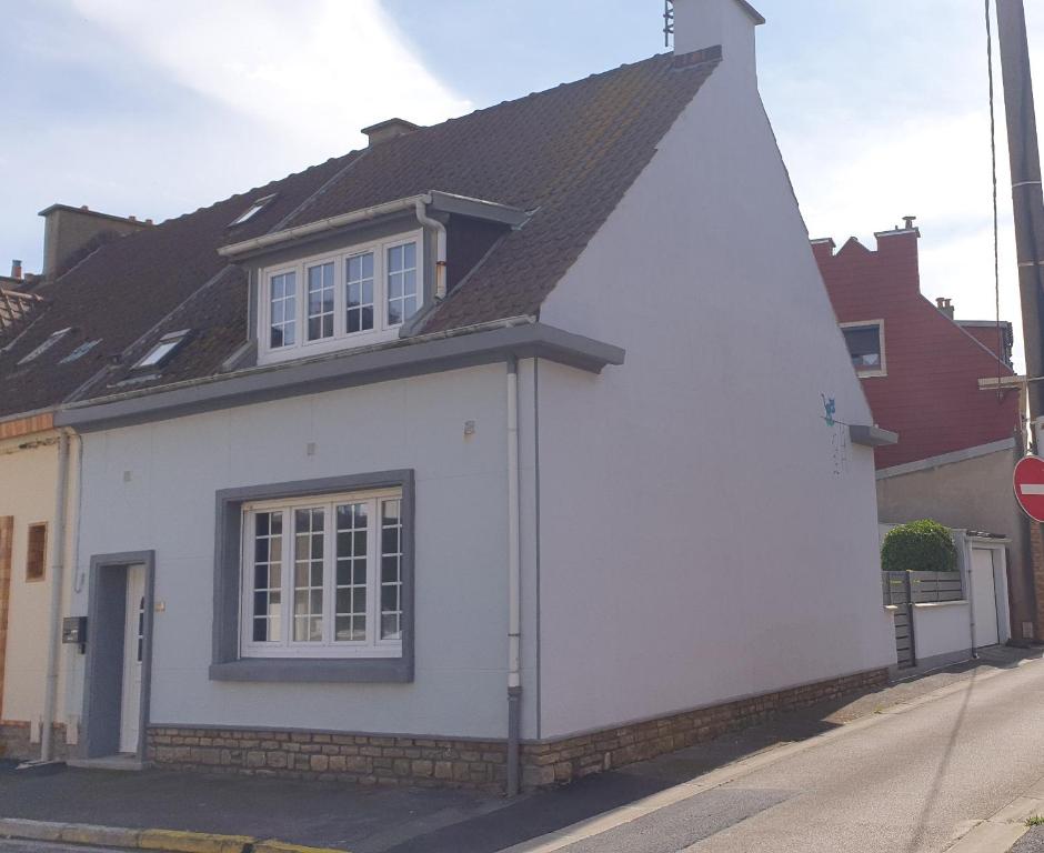 une maison blanche avec un toit noir dans une rue dans l'établissement The Cat ,maison de vacances à 50m de la plage, à Le Portel