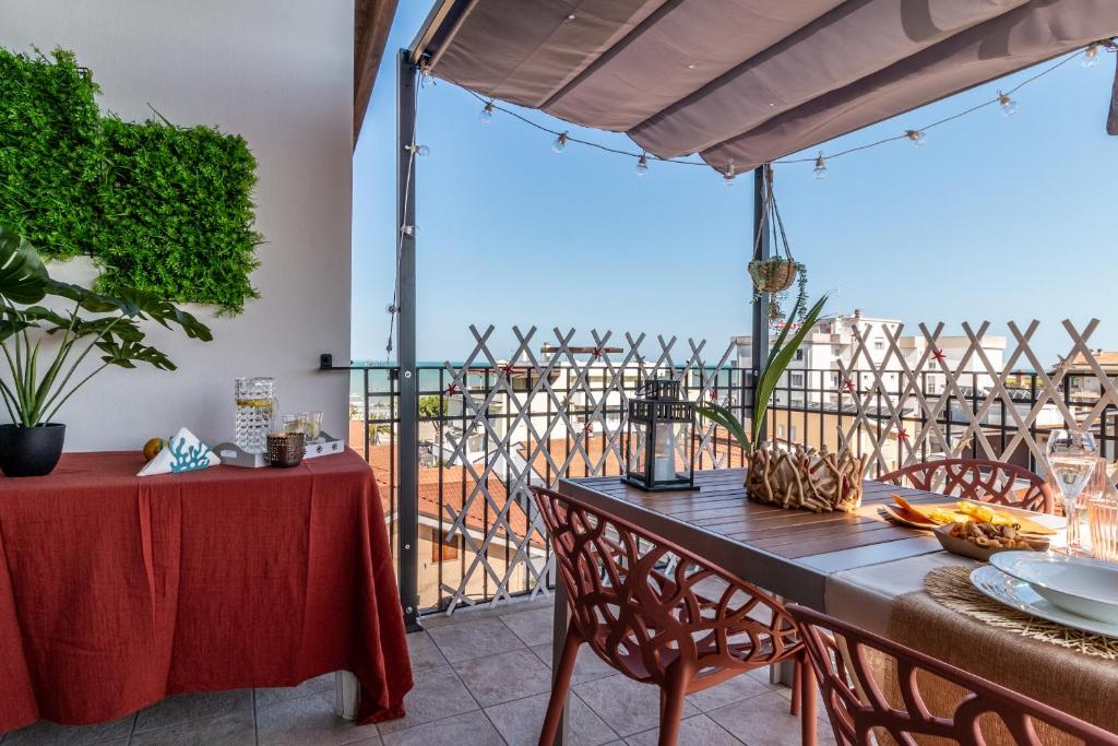 a table and chairs on a balcony with a view at Gioiello Marino Holiday apt Tortoreto - Bike e Wi-Fi in Tortoreto Lido