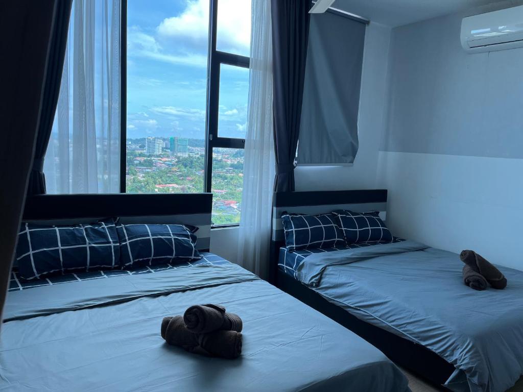 2 camas en una habitación con ventanas grandes en ITCC Manhattan Suites by Stay In 6pax en Kota Kinabalu