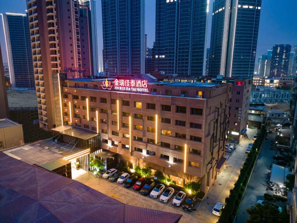 un edificio con un estacionamiento en una ciudad por la noche en Jinrui Jiatai Hotel Xiamen - Convention and Exhibition Center-Gudishi Subway Station, en Xiamen