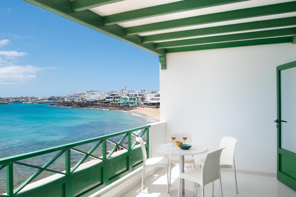 a balcony with a table and chairs and a view of the ocean at Blancazul Avenida in Playa Blanca