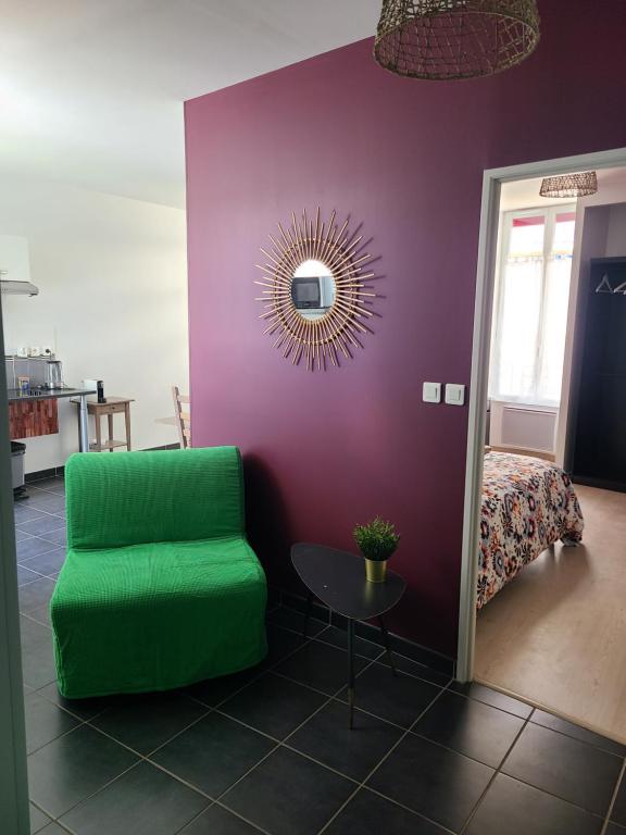 Cette chambre comprend une chaise verte et un mur violet. dans l'établissement APPT CENTRE VILLE GARE HOPITAL IUT, à Roanne