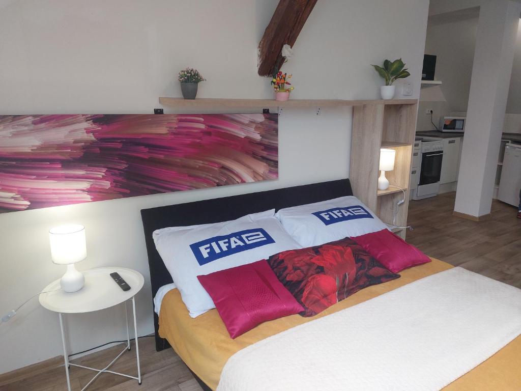 a bedroom with a bed with a painting on the wall at Byt Komenského v centru in Hradec Králové