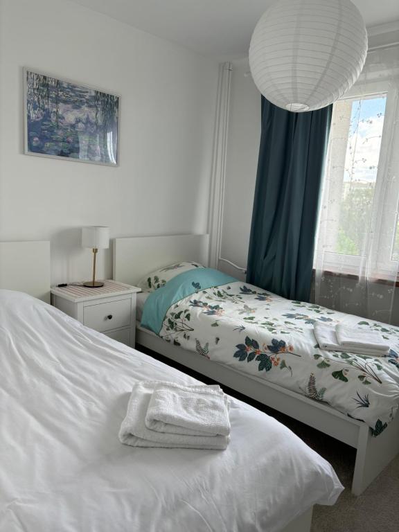 a bedroom with two beds and a lamp and a window at Nocleg na doby S 61 ROAD in Suwałki