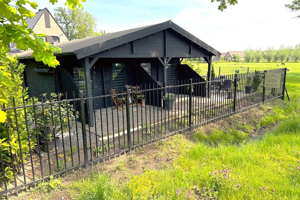 una recinzione nera davanti a un capanno di B&B op de Heuvelrug a Leersum