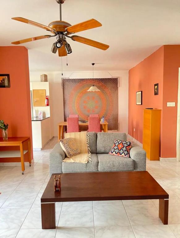 ein Wohnzimmer mit einer Couch und einem Deckenventilator in der Unterkunft Pafia A in Paphos City