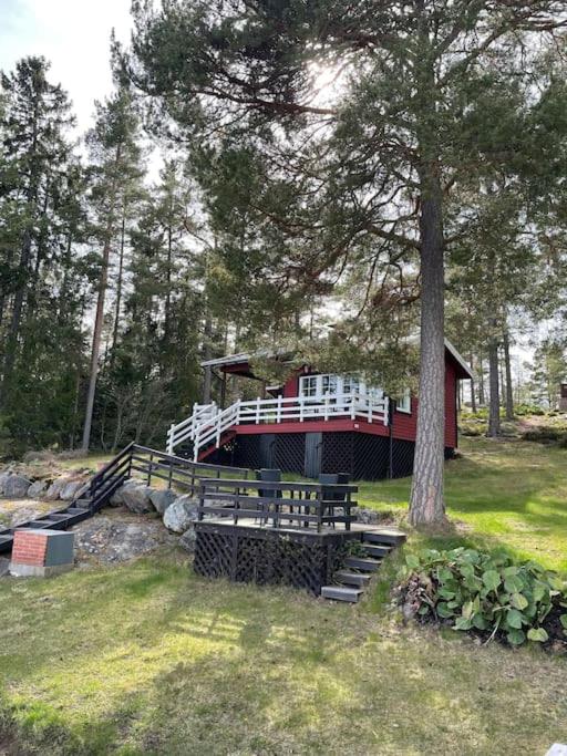 a bridge with a bench and a tree in a field at Edvin rantamökki in Taalintehdas