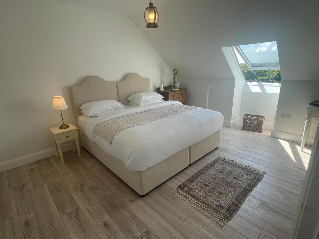 a bedroom with a large white bed and a window at Brand New Deluxe Sea View Apartment in Inis Mor