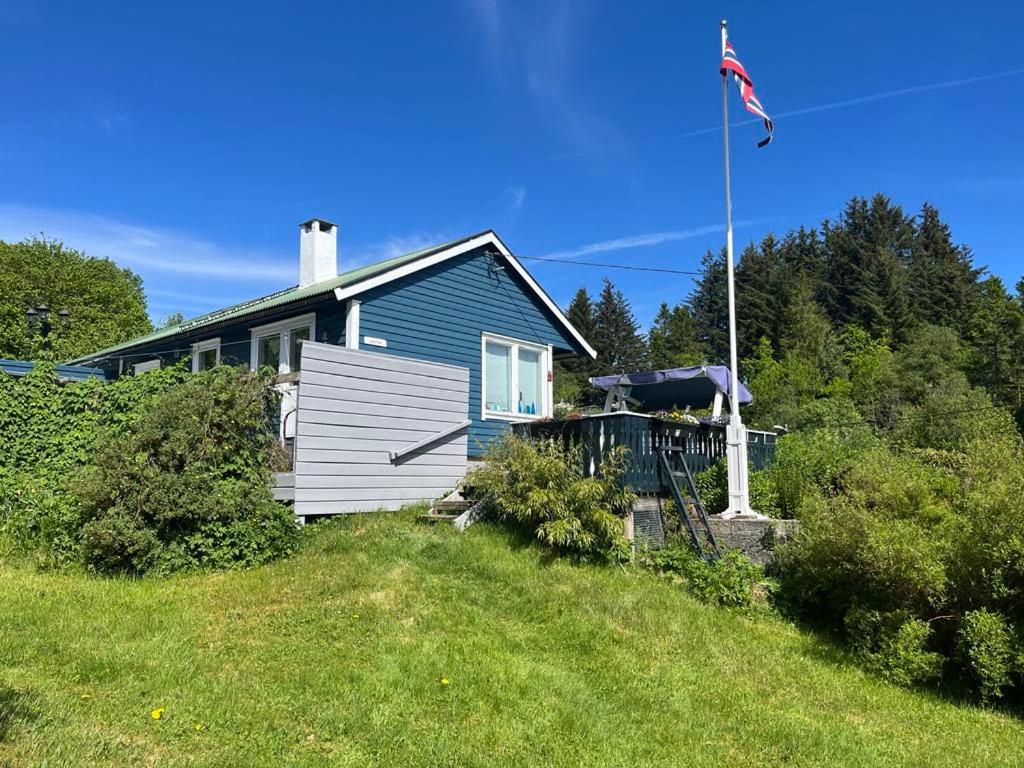 una casa blu in cima a una collina con una bandiera di 4 Person Holiday Home Sletta 