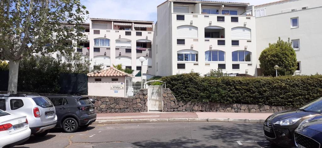 un parking avec des voitures garées devant un bâtiment dans l'établissement Charmant Studio Centre Port du Cap d'Agde, au Cap d'Agde