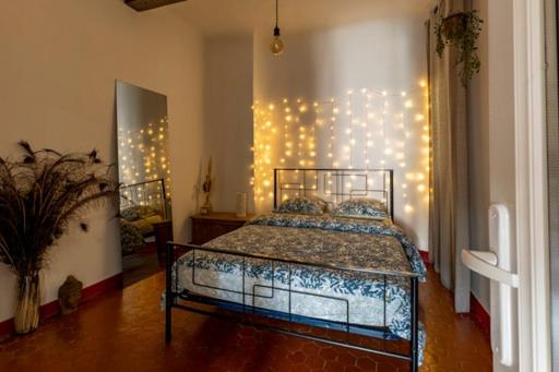 a bedroom with a bed with lights on the wall at Le cosy in Marseille