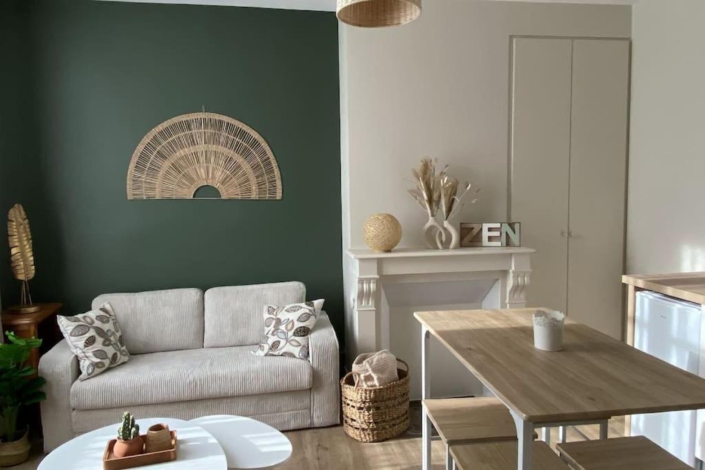 a living room with a couch and a table at Le cocon du Faubourg in Vendôme