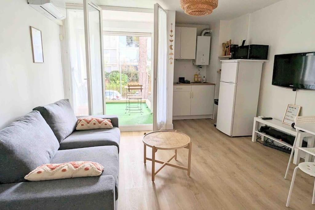 un salon avec un canapé et une table et une cuisine dans l'établissement Studio climatisé 4 pers, balcon, parking, à La Grande Motte