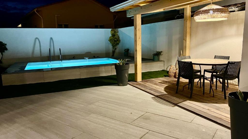 een patio met een zwembad en een tafel en stoelen bij U PINU - Maison 3 chambres - piscine privée exclusive - plage à pied - 3 bedroom house - private swimming pool - beach access on foot in Bastia
