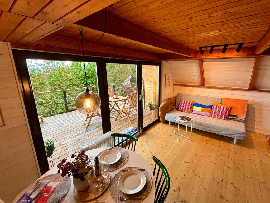 Habitación con mesa, sofá y patio. en House Of Harry - horská chata, en Liberec