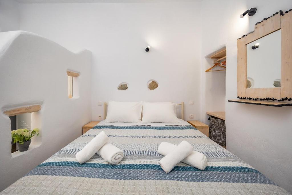 um quarto com uma cama com almofadas brancas em Feel the Serenity 2 em Galini