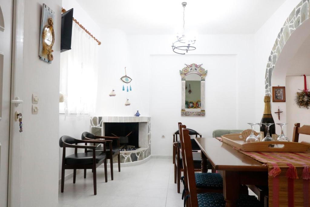 une salle à manger avec une table, des chaises et une cheminée dans l'établissement Arco In Pietra, à Apolakkiá