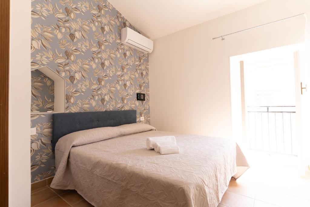a bedroom with a bed with a blue and gold wallpaper at La casetta in Tortoreto Lido