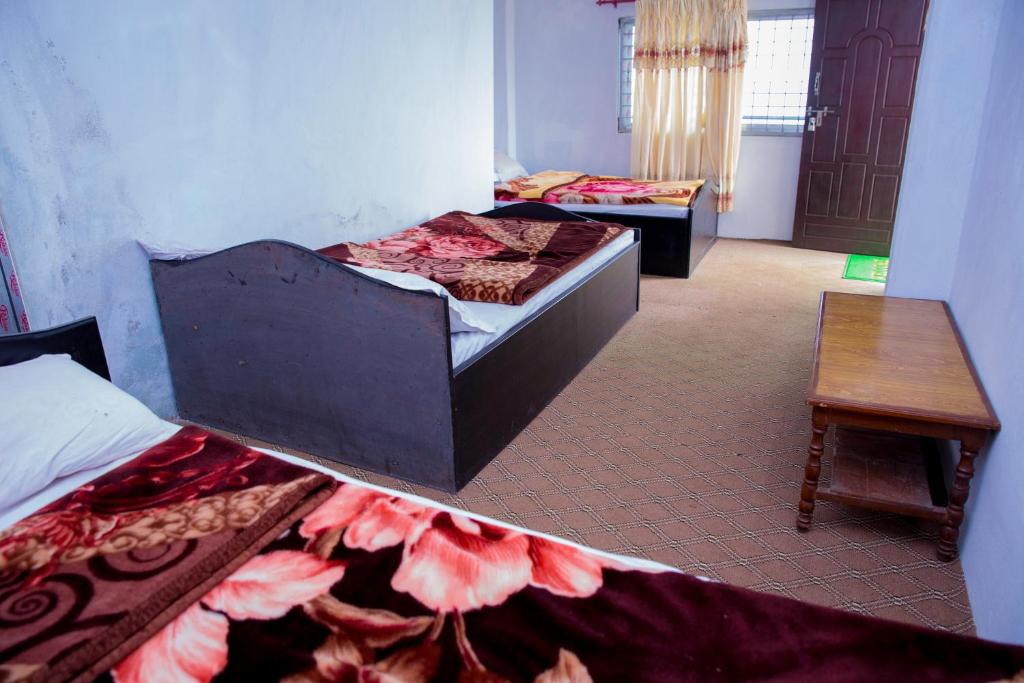 DeorāliDouble Lake View Homestay的有两张床和一张桌子的房间