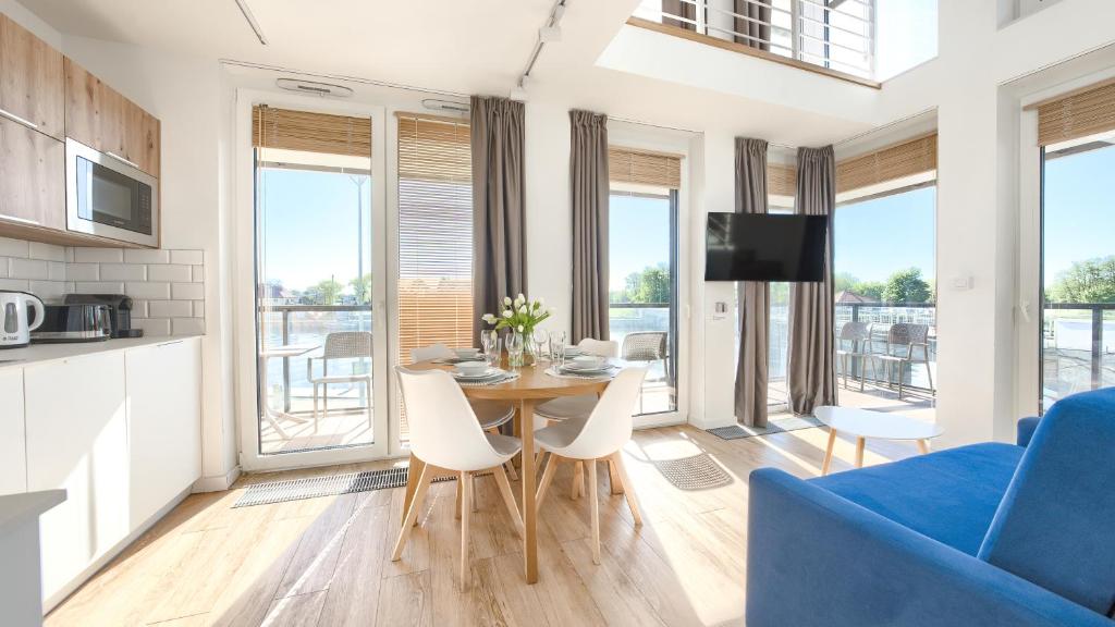uma sala de estar com uma mesa e um sofá azul em Apartamenty Sun & Snow Lighthouse em Mrzeżyno