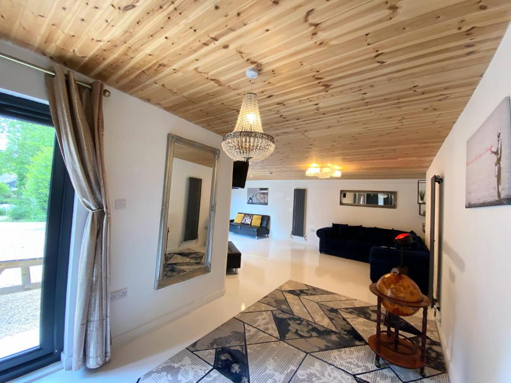 uma sala de estar com um tecto de madeira e um lustre em Hunters Hideaway-Hot Tub-Wiltshire-Groups em Warminster