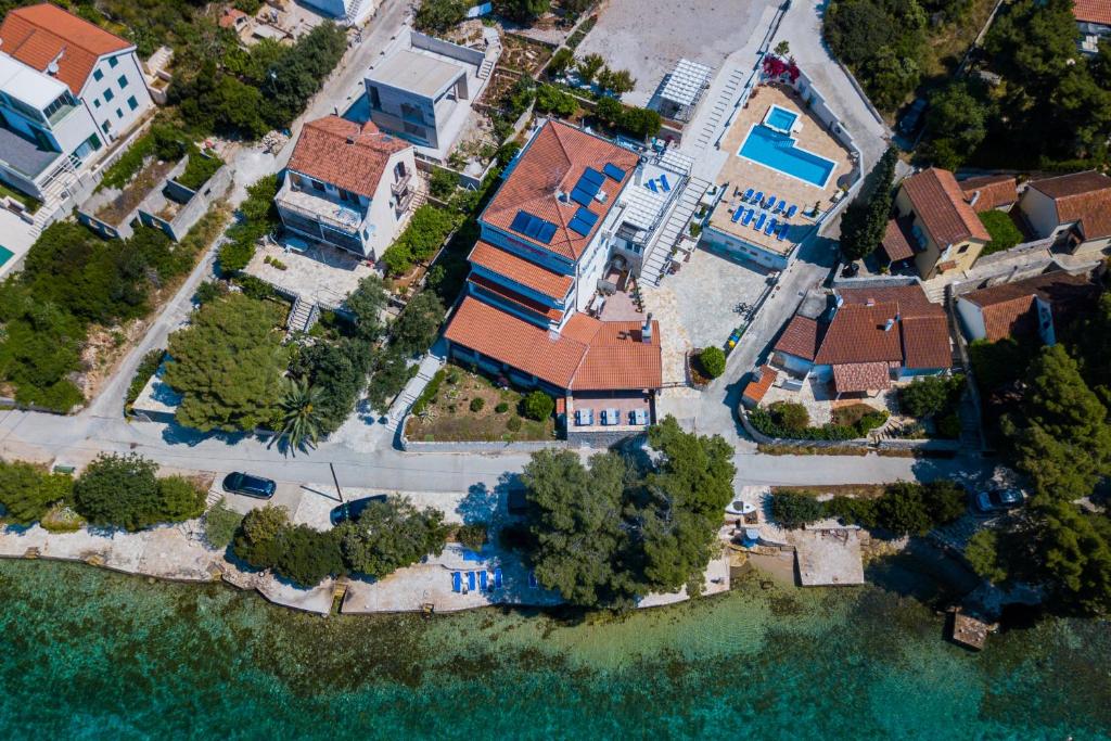 une vue aérienne sur une maison à côté de l'eau dans l'établissement Boutique Guesthouse Sveti Petar, on the beach, heated pool, restaurant & boat berth - ADULT ONLY, à Nečujam
