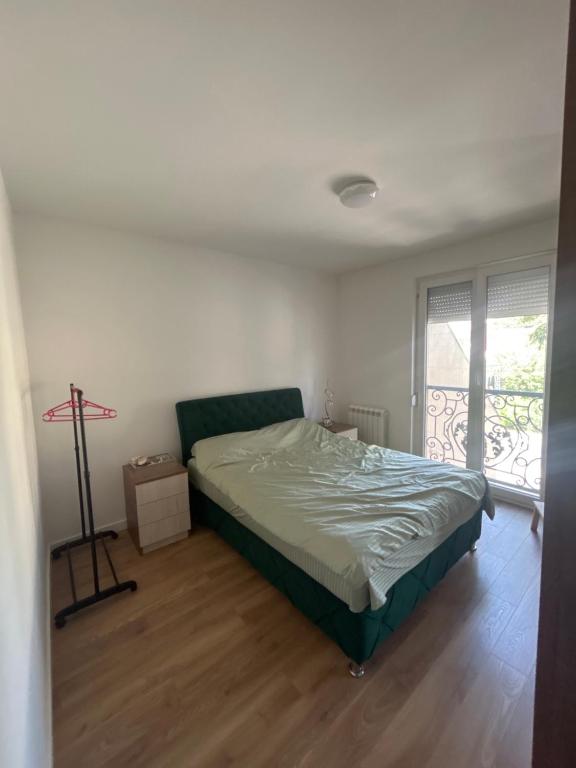 a bedroom with a bed in a room with a window at Stan na dan Zvezdara in Zvezdara