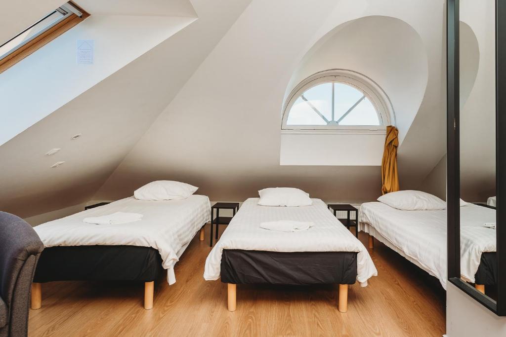three beds in a room with a window at 16eur - Fat Margaret's in Tallinn