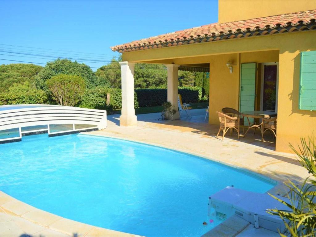 une piscine devant une maison dans l'établissement Maison avec piscine couverte et terrasse barbecue - 6 couchages - Sainte Maxime - FR-1-226-311, à Sainte-Maxime