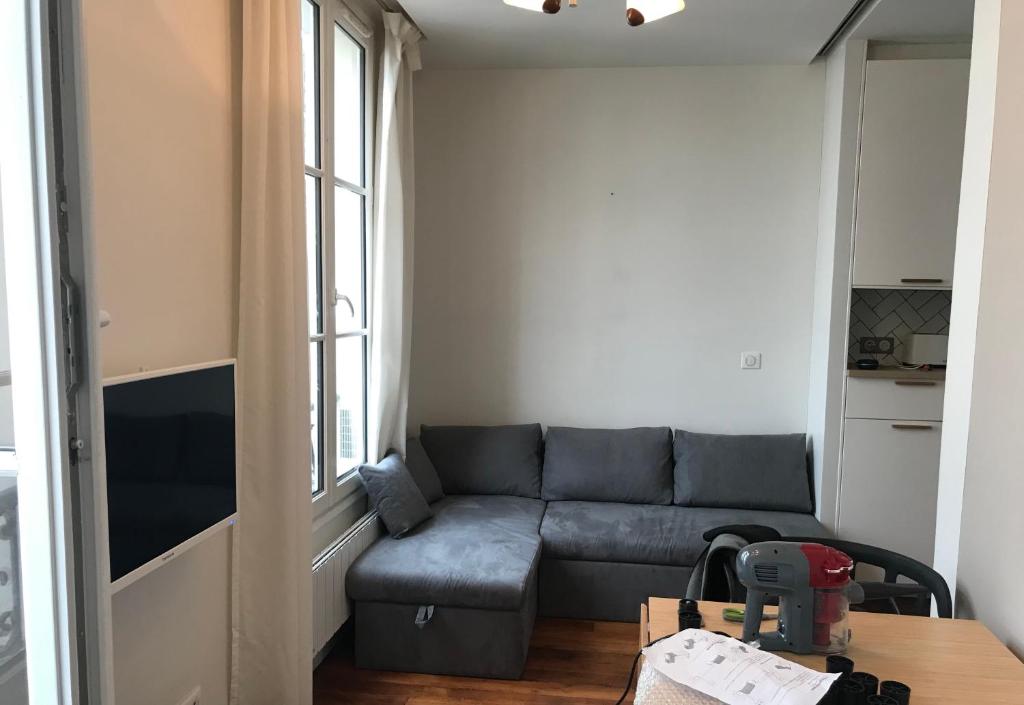 un salon avec un canapé et une table dans l'établissement 1 BDR Cosy Parisian Appartment, close to Marais (Paris 11ème), à Paris