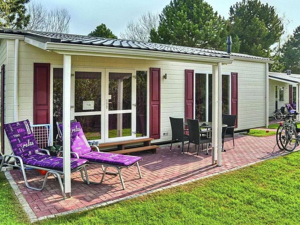 a house with purple chairs on a patio at Mobile home "Romantic Suite" M 160 in Fehmarn