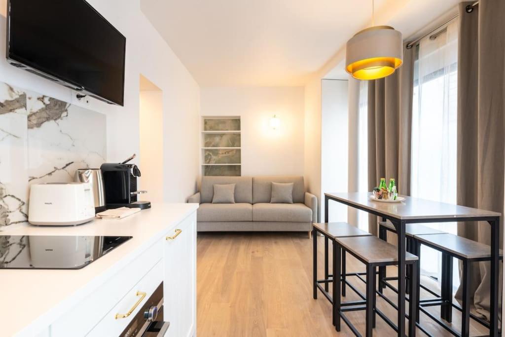 une cuisine et un salon avec une table et un canapé dans l'établissement Cosy and Charming flat - 15ème - convention, à Paris
