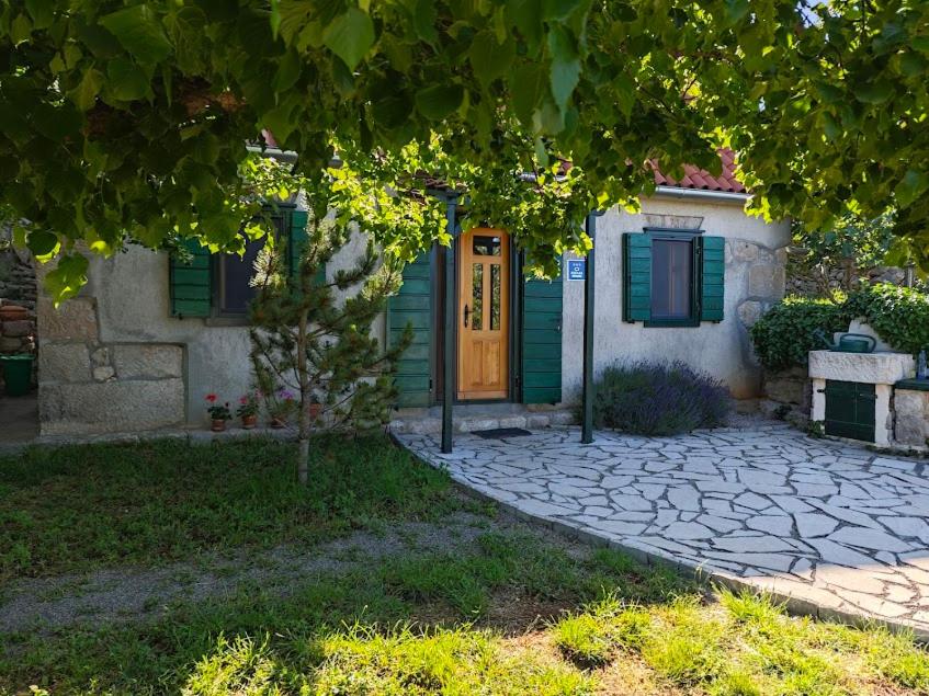 una casa con puerta amarilla y persianas verdes en House Kaja, en Jablanac