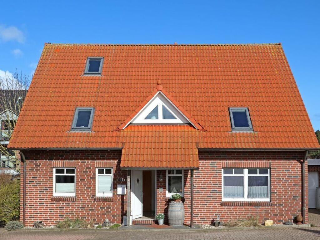 a red roofed house with an a sign on it at House in Legde "East" in Norderney